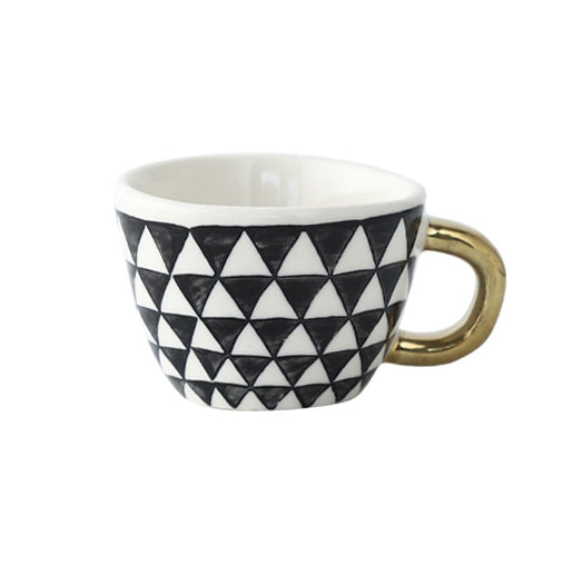 Tasse mit abstraktem geometrischem Muster und goldenem Henkel