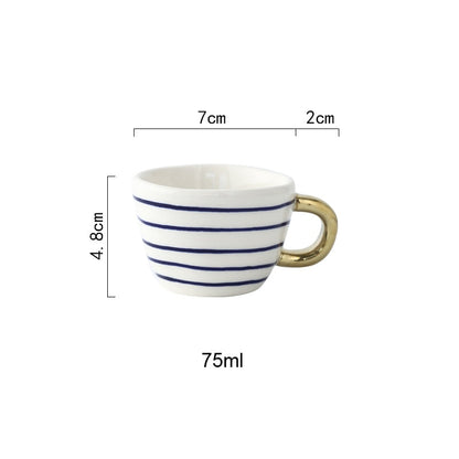 Tasse mit abstraktem geometrischem Muster und goldenem Henkel