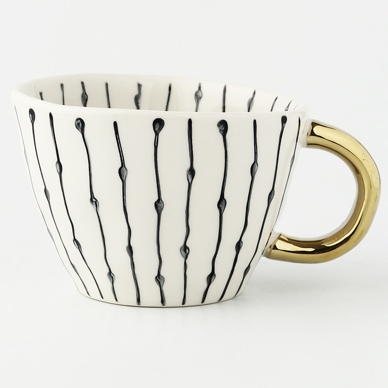 Tasse mit abstraktem geometrischem Muster und goldenem Henkel