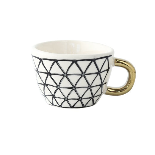 Tasse mit abstraktem geometrischem Muster und goldenem Henkel