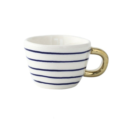 Tasse mit abstraktem geometrischem Muster und goldenem Henkel