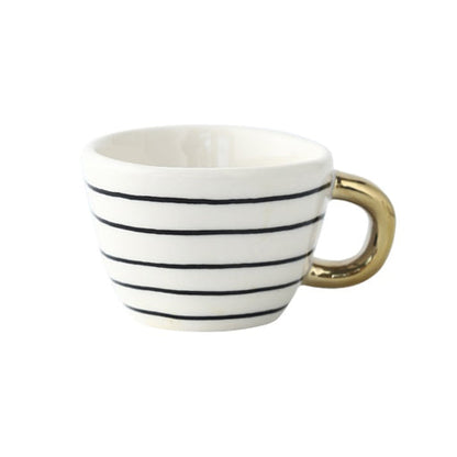 Tasse mit abstraktem geometrischem Muster und goldenem Henkel